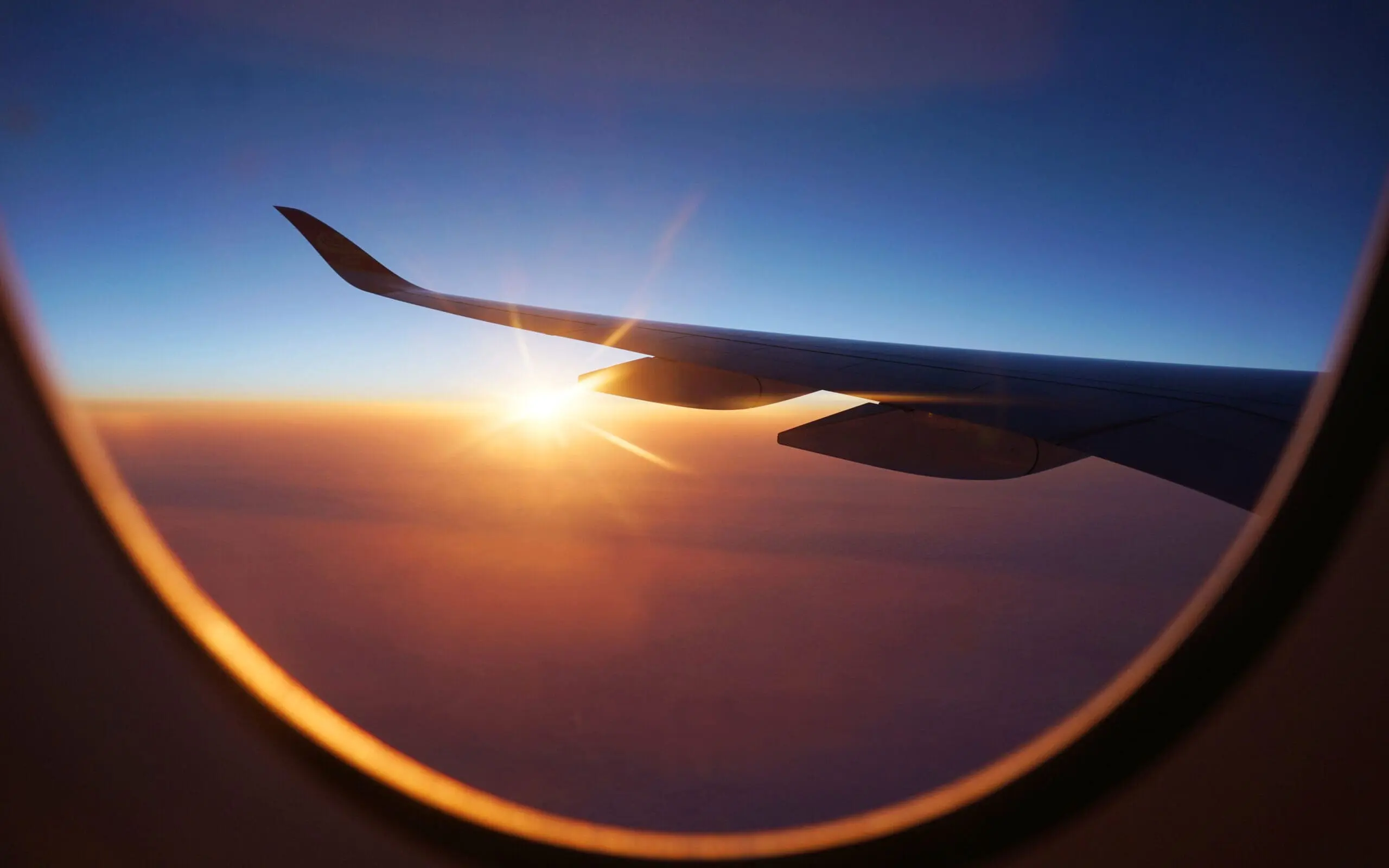 sunlight through airplane window from wing during sunrise